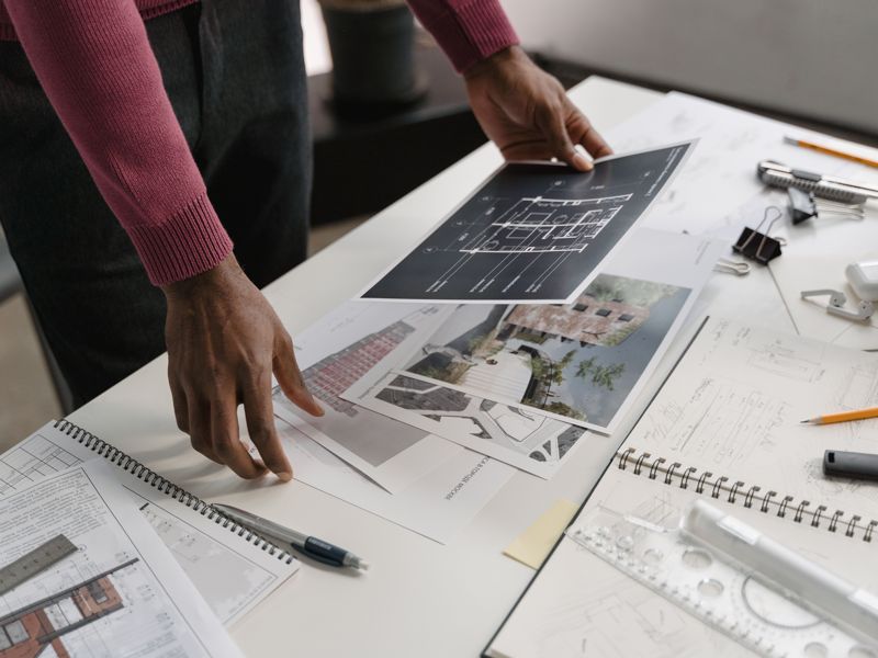 Hands working over architectural plans
