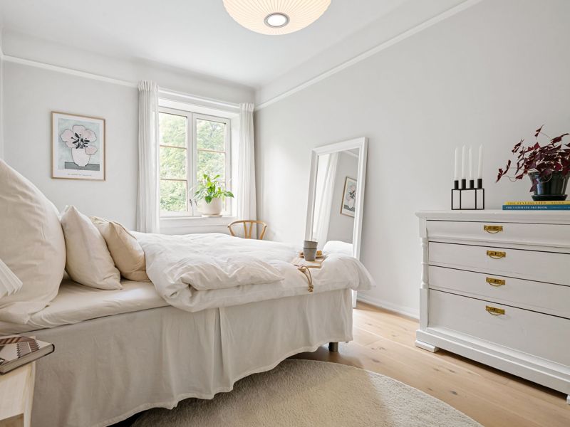 A bright, tidy bedroom with natural light