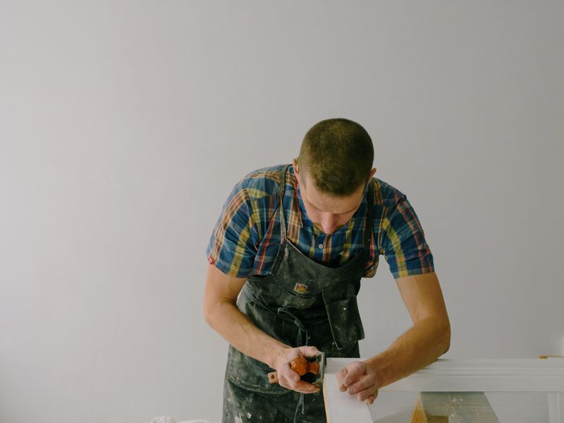 A carpenter planing a timber frame