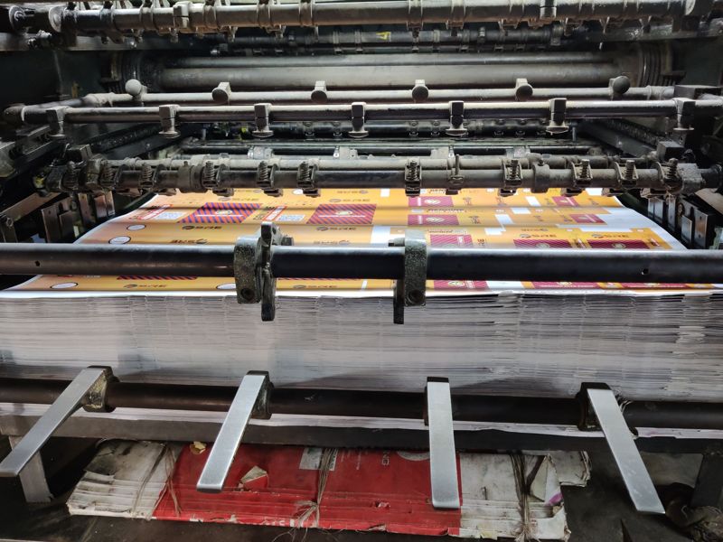 Printed sheets running through an industrial printing press
