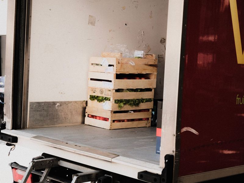 A crate of fresh produce loaded in the back of a delivery truck