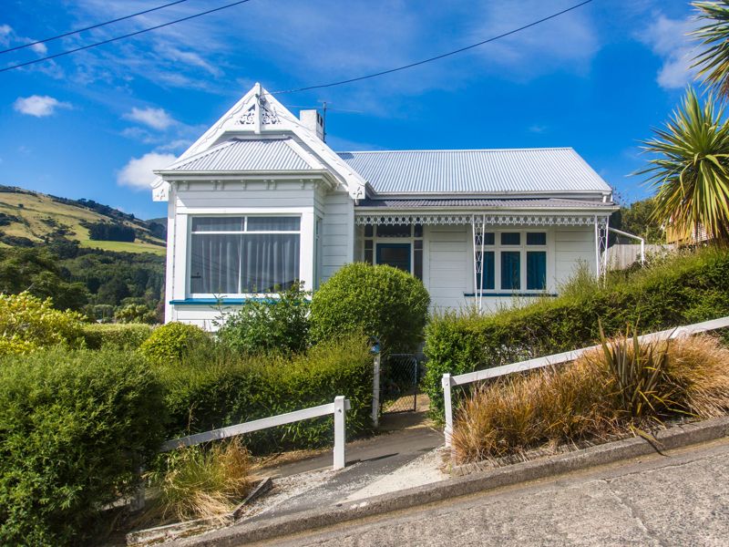A villa on a hillside street under a clear blue sky