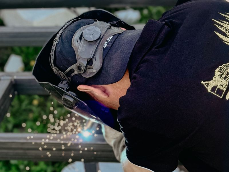 A welder grinding steel as sparks fly