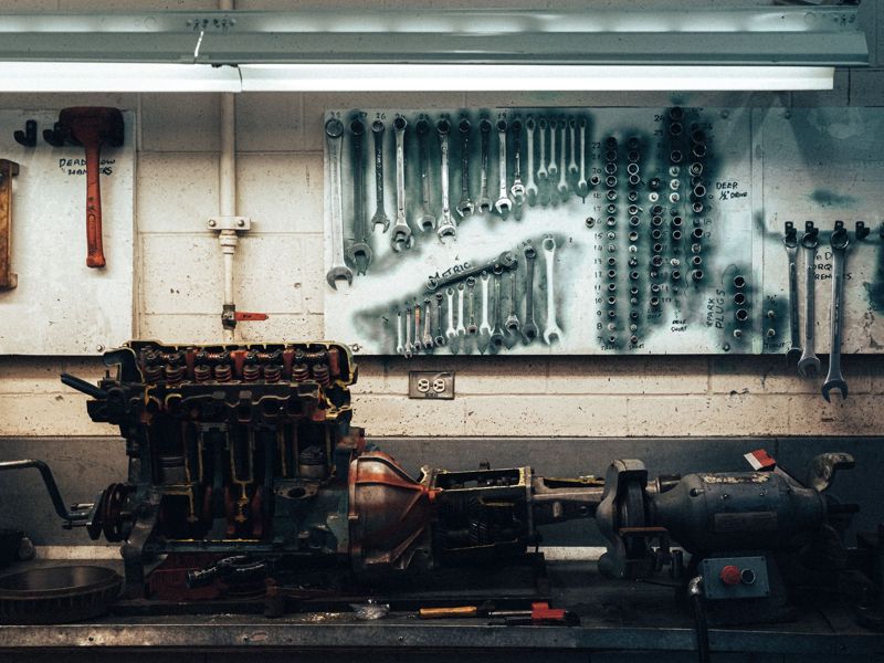 A workshop wall of tools above an engine on the bench